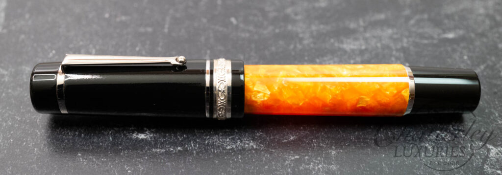 The Dolcevita embodies an acrylic resin barrel cast in a brilliant tiger orange and a handcrafted silver band using old skills passed down through generations.