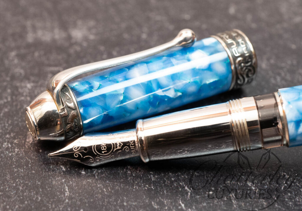 Close-up of Aurora fountain pen showing handcrafted 18K gold nib and proprietary marbled Auroloide resin barrel